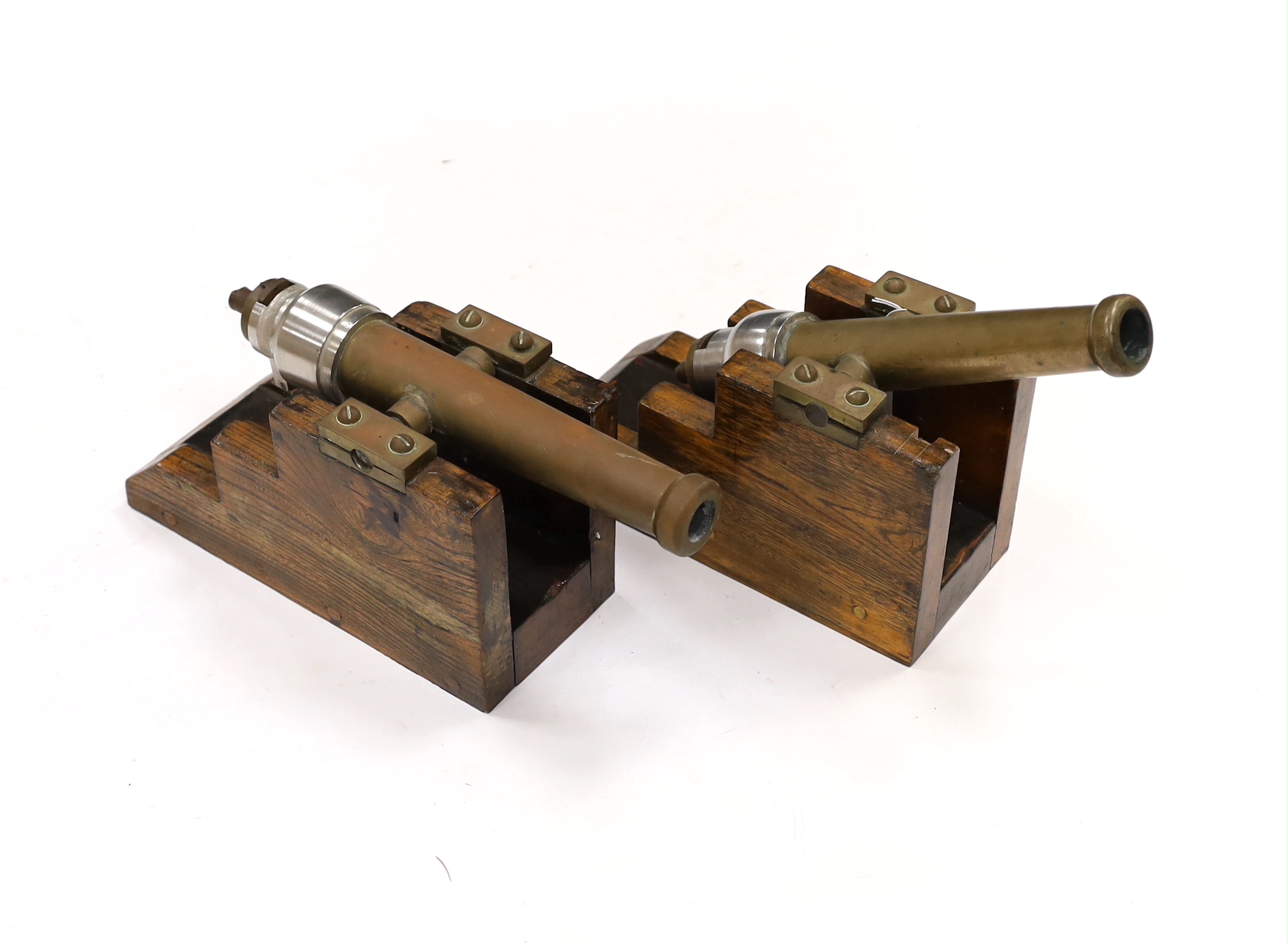 A near pair of breech loading brass and steel starting cannons, on elm stands, longest barrel 24.5cm